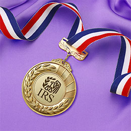 Gold sports medal with red, white and blue neck ribbon on a purple satin background. IRS logo in the center of the gold medal.