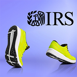 Bright yellow tennis shoes walking in front of a purple background. Black IRS logo.